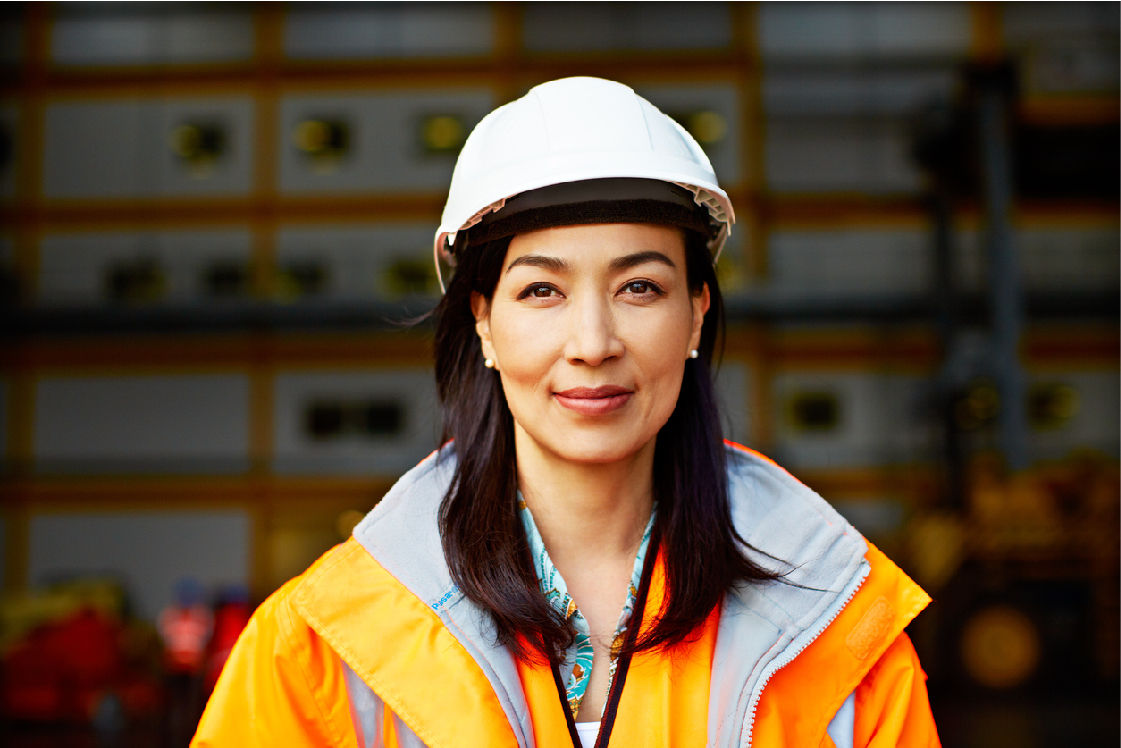 A women in a construction outfit smiling